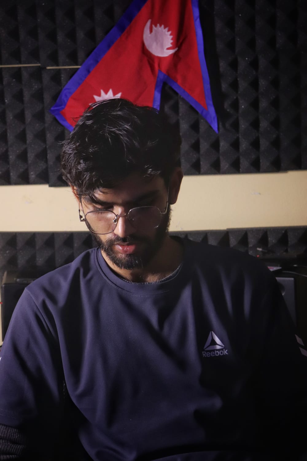 Prashant Paneru in front of a Nepali flag